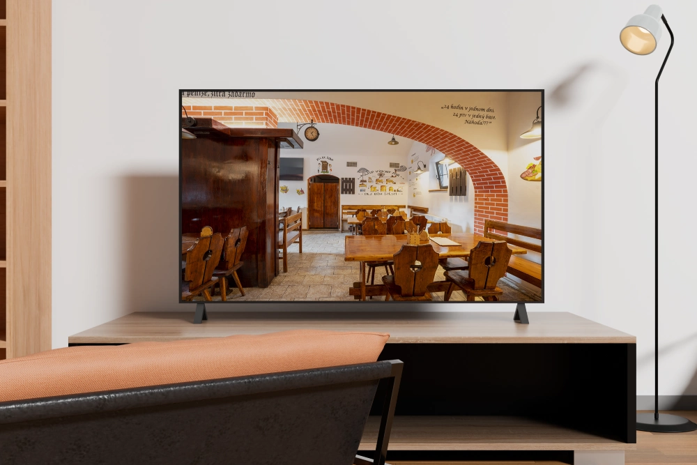 Záběr interiéru restaurace U Dvou pupků zobrazený na televizní obrazovce – prezentační video restaurace.